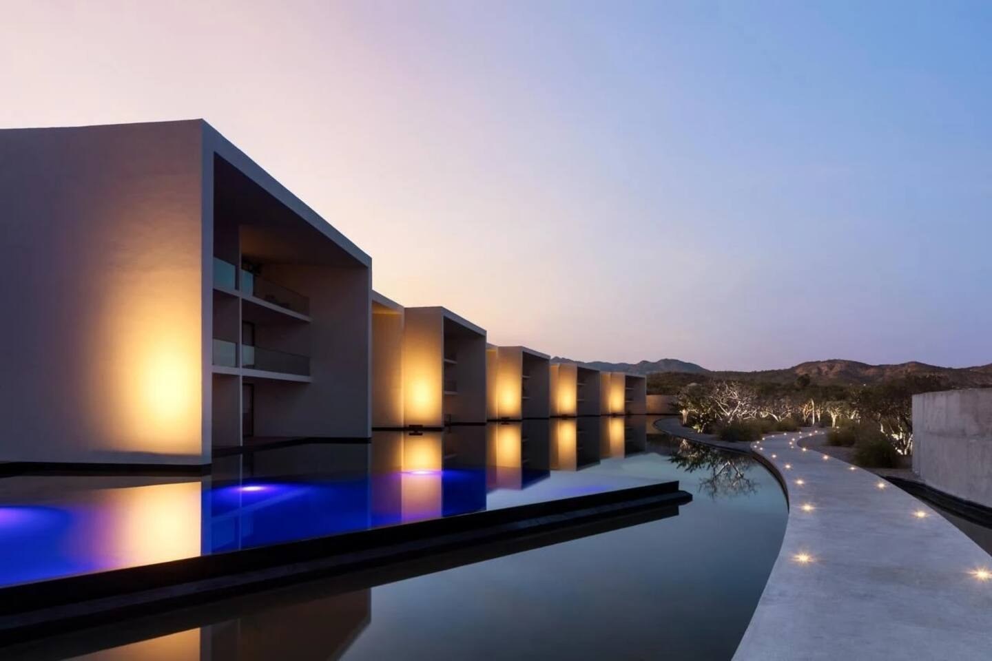 Cora's infinity pool at dusk with views over San José del Cabo toward the Sea of Cortez