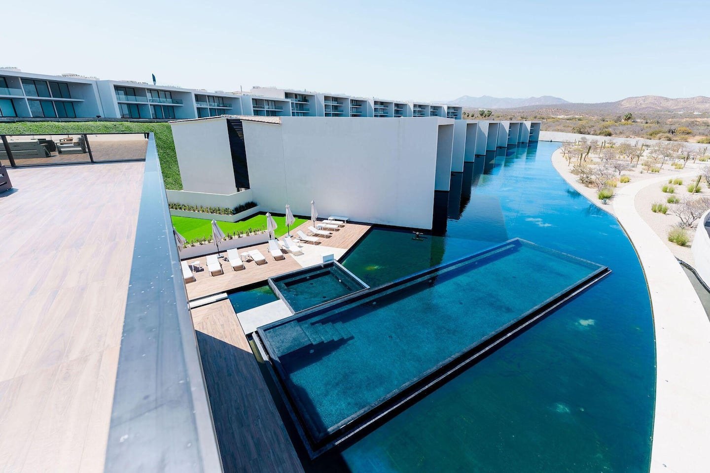 Aerial view of Cora's resort-style swimming pool winding through the residence terraces