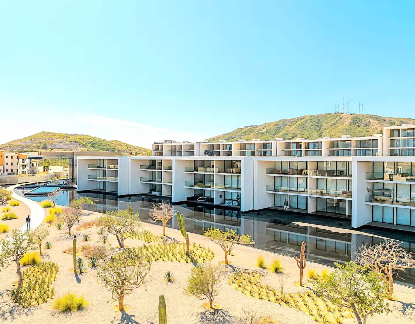 Cora's modern white residence buildings with desert landscaping and mountain backdrop